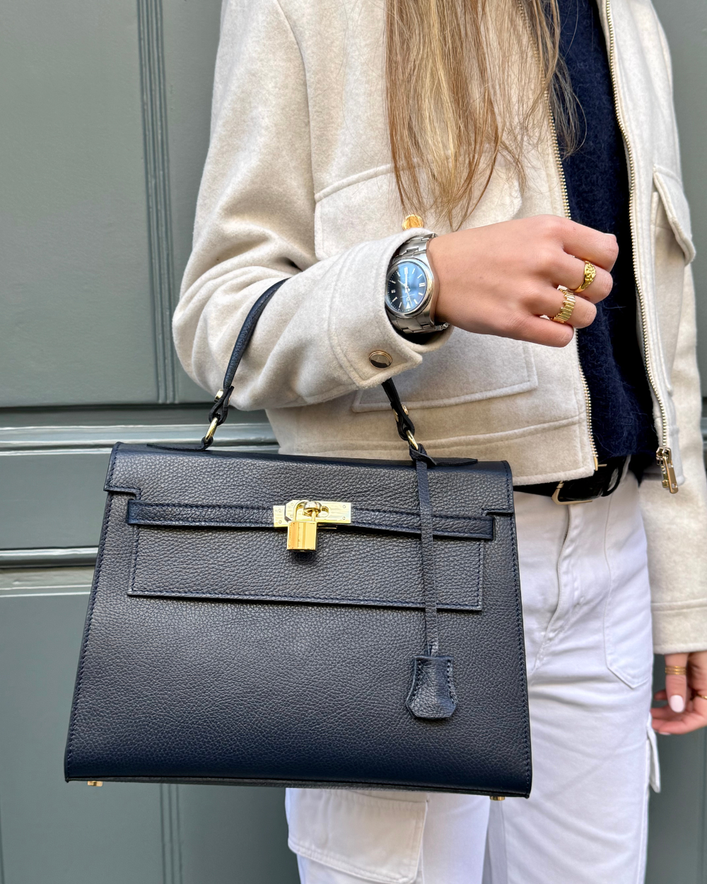 Modelo llevando el bolso ICONIC 1984 BLUE, mostrando su tamaño perfecto y su estilo sofisticado. Este bolso de mujer de lujo es ideal para completar cualquier look elegante, ya sea para una reunión de trabajo, una cena especial o un evento importante. Su diseño atemporal y refinado lo convierte en un must-have en cualquier colección de accesorios de moda.
