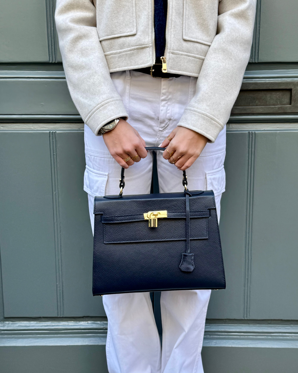 Modelo llevando el bolso ICONIC 1984 BLUE, mostrando su tamaño perfecto y su estilo sofisticado. Este bolso de mujer de lujo es ideal para completar cualquier look elegante, ya sea para una reunión de trabajo, una cena especial o un evento importante. Su diseño atemporal y refinado lo convierte en un must-have en cualquier colección de accesorios de moda.