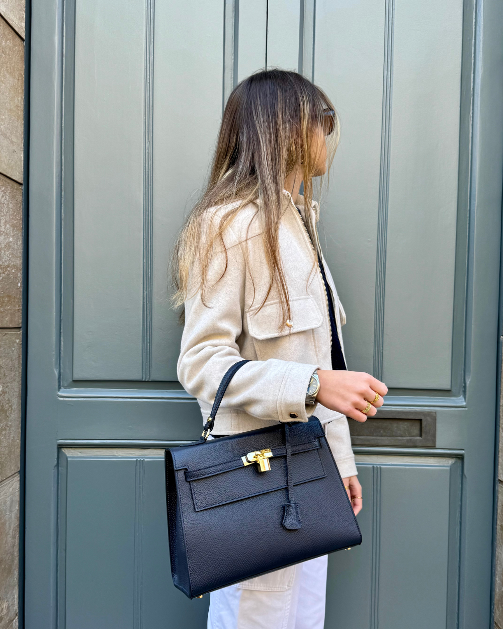 Vista lateral del bolso ICONIC 1984 BLUE, un bolso de lujo para mujer fabricado en cuero italiano azul de alta gama. Su diseño estructurado mantiene su forma impecable, mientras que el acabado en piel lisa y el sutil relieve de los bordes realzan su estética elegante. La silueta alargada y la base reforzada garantizan estabilidad y resistencia para un uso diario sofisticado.