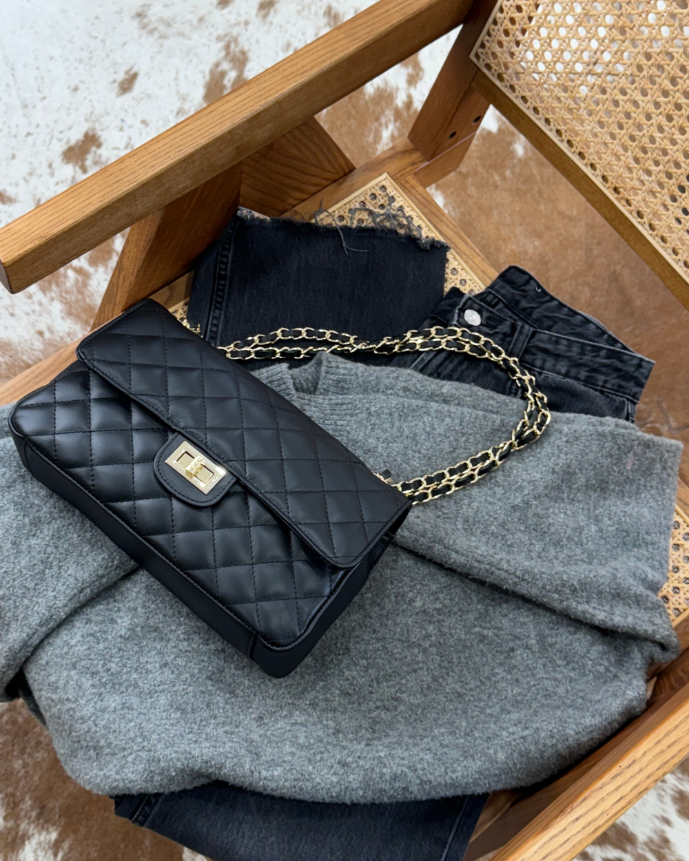 El bolso Juliette Black acompañado de accesorios como gafas de sol y joyería, resaltando su versatilidad y capacidad de combinación con distintos estilos.