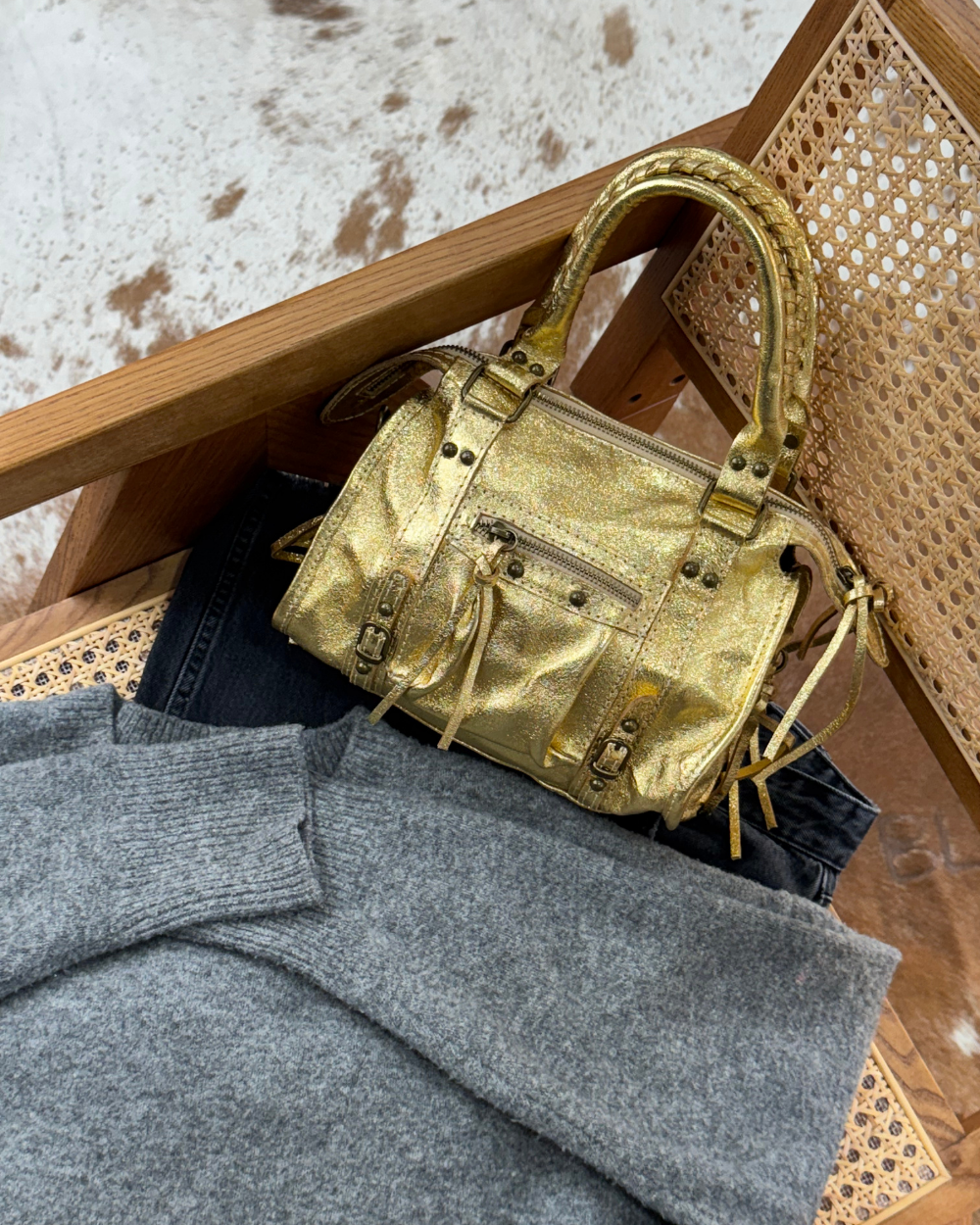 Fotografía del Mini Bolso Stargirl Gold con joyas y otros accesorios, mostrando su capacidad para realzar cualquier outfit.