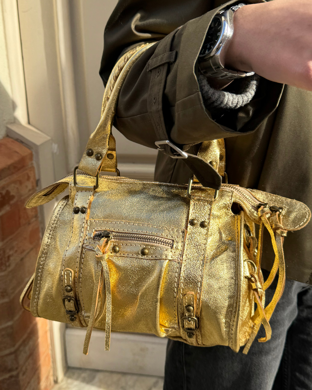 El Mini Bolso Stargirl Gold de Seis Doses en un entorno moderno y elegante, resaltando su acabado metálico y su diseño estructurado.