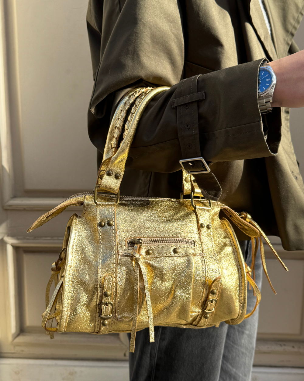 Vista lateral del Mini Bolso Stargirl Gold, resaltando su perfil estructurado y el brillo sutil de su material dorado.